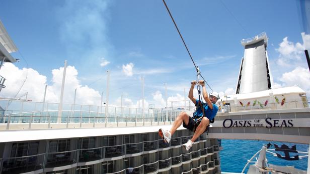 Ein Mann fährt mit einer Seilrutsche auf der „Oasis of the Seas“.