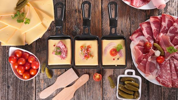 Wie Fondue gilt Raclette in der Schweiz als Nationalspeise, dort werden Erdäpfel mit Schale und eingelegtes Gemüse dazu serviert.