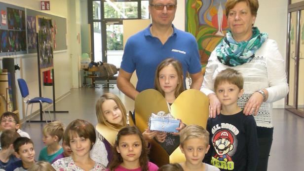 Christian Jordanich übergab die Spendenbox an Direktorin Susanna Pauer und ihre Schüler