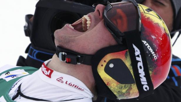 Ein Mann mit einem Helm in den Farben der deutschen Flagge schreit.