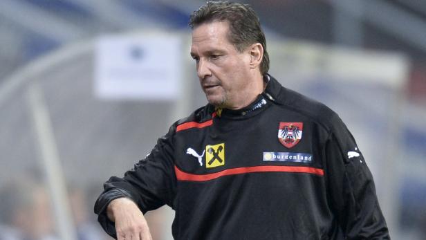 Ein Mann in einer schwarzen Trainingsjacke mit dem österreichischen Wappen.