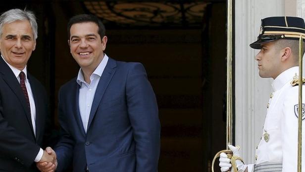 Zwei Männer in Anzügen schütteln sich die Hände, während Ehrenwachen Spalier stehen.