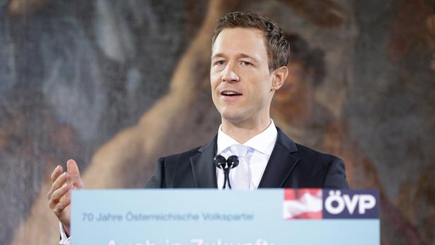 Ein Mann in Anzug spricht vor einem Mikrofon mit dem ÖVP-Logo.