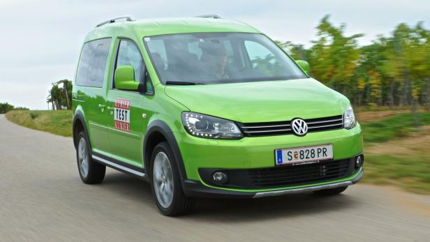 Ein grüner VW Caddy fährt auf einer Landstraße.