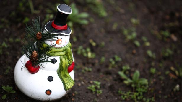 ABD0045_20141221 - Ein Schneemann aus Ton sitzt am 21.12.2014 bei milden Temperaturen auf dem Grün eines Vorgartens in Bamberg (Bayern). Foto: David Ebener/dpa +++(c) dpa - Bildfunk+++