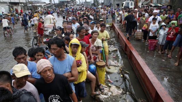 Menschen warten auf eine Schale Reis in Tacloban. Die ersten Hilfslieferungen sind bereits angekommen.