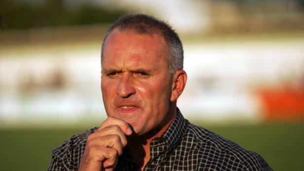 Ein Mann mit kariertem Hemd denkt nach.