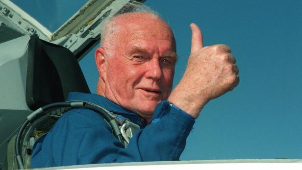 John Glenn gibt im Cockpit eines Flugzeugs einen Daumen nach oben.