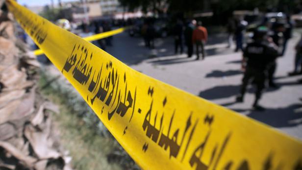 Gelbes Absperrband mit arabischer Schrift versperrt einen Bereich.