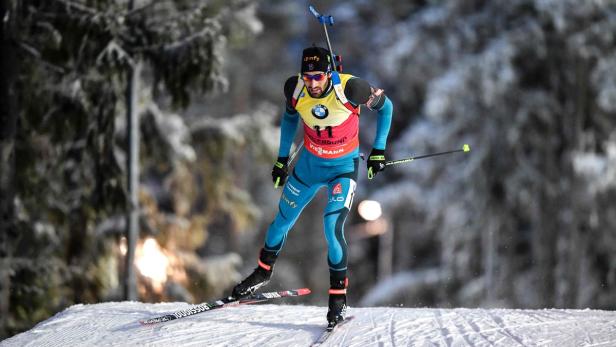 Ein Biathlet auf Skiern während eines Wettkampfs im Schnee.