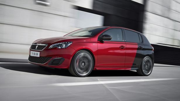 Ein roter Peugeot 308 GTi fährt auf einer Straße.