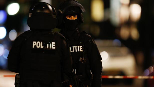 Zwei Polizisten in voller Montur stehen bei Nacht auf der Straße.