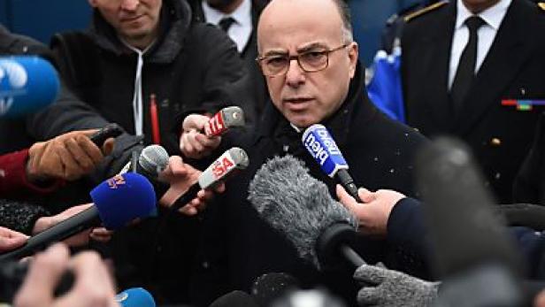 Ein Mann mit Brille spricht in mehrere Mikrofone.