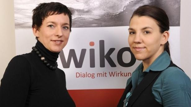 Zwei Frauen posieren vor einem „Wiko“-Logo.