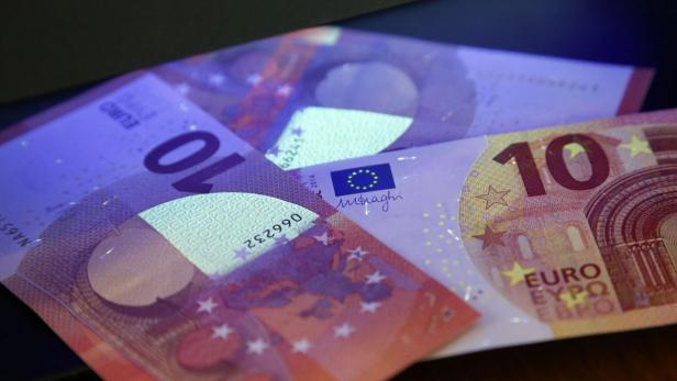Mehrere 10-Euro-Scheine unter UV-Licht zur Echtheitsprüfung.