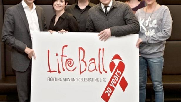Eine Gruppe von Menschen hält ein Schild mit der Aufschrift „Life Ball – Fighting AIDS and Celebrating Life 20 years“.