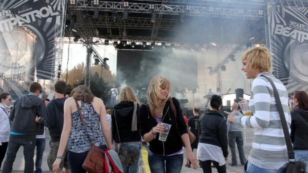 Menschenmenge genießt ein Konzert auf einer Open-Air-Bühne.