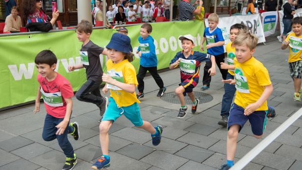 Eine Gruppe Kinder nimmt an einem Laufwettbewerb in der Stadt teil.