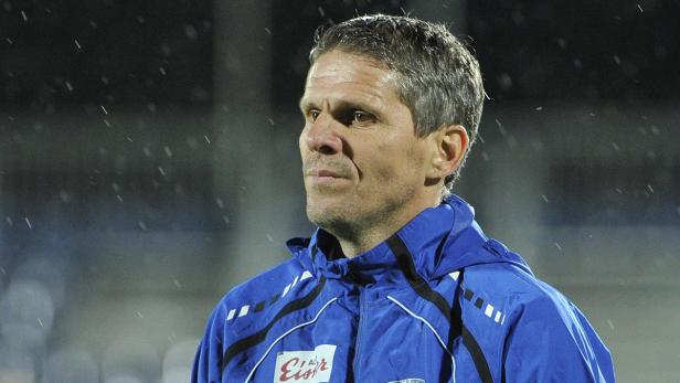 Ein Mann in einer blauen Jacke steht im Regen.