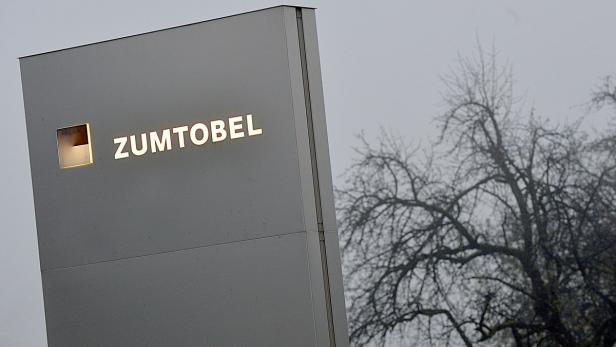 Das Firmenschild von Zumtobel vor einem Baum an einem trüben Tag.