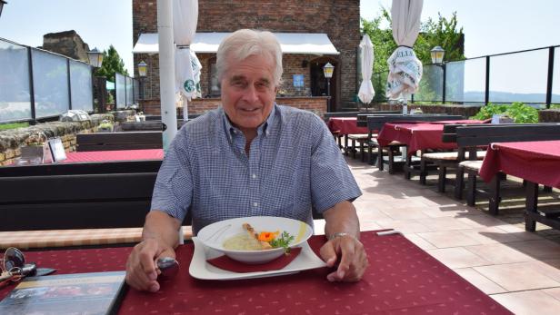 Frank Hoffmann genießt die Vorspeise – eine Schwammerlsuppe – auf der Terrasse des Burgrestaurants. Neben der guten Küche schätzt er die tolle Aussicht