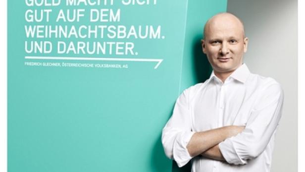 Ein Mann steht neben einem Werbeplakat der Münze Österreich, das für Gold als Anlage wirbt.