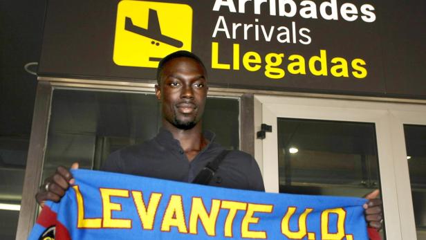 epa03830812 French soccer player Remi Gomis holds a scarf of Spanish team Levante UC upon his arrival at Valencia&#039;s airport, eastern Spain, 19 August 2013. Gomis signed a two-year contract with the Spanish team. EPA/Biel Alino