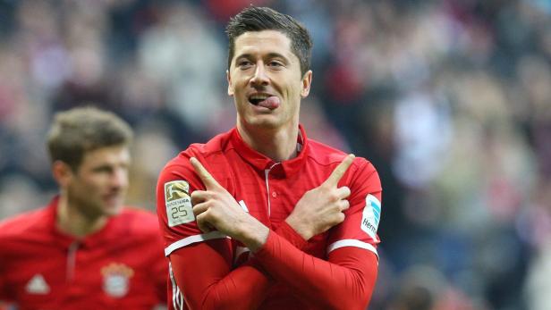 Robert Lewandowski, im roten Bayern München Trikot, streckt die Zunge heraus.