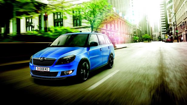 Ein blauer Škoda Fabia fährt auf einer Straße in einer Stadt.