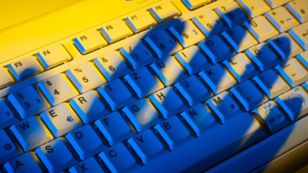 Computertastatur und Schatten einer Hand. Diebstah… Der 24-Jährige soll auch Daten ausgespäht haben.