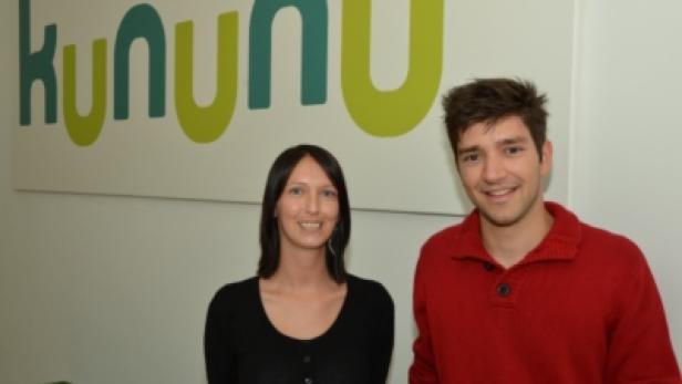 Eine Frau und ein Mann stehen vor dem Kununu-Logo.