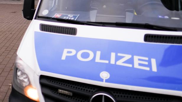 Detailansicht eines weißen Polizeiwagens mit blauem Schriftzug.