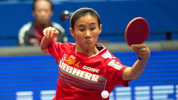 Eine Tischtennisspielerin beim Aufschlag.