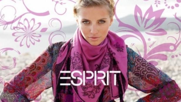 Eine Frau mit blonden Haaren trägt einen Schal und Kleidung der Marke Esprit.