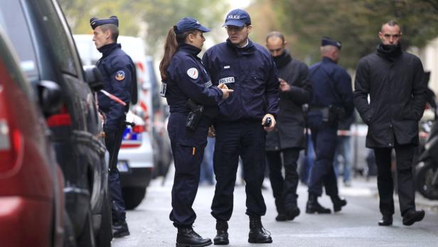 Mehrere Polizisten stehen auf einer Straße in Frankreich.