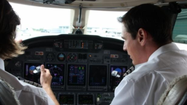 Zwei Piloten sitzen im Cockpit eines Flugzeugs.