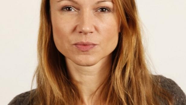 Porträt einer Frau mit langen, gewellten, braunen Haaren.