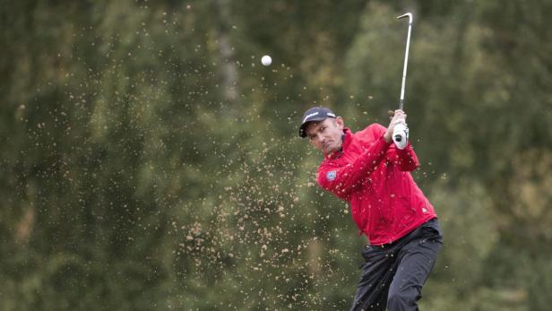 Ein Golfspieler schlägt einen Ball aus dem Sandbunker.