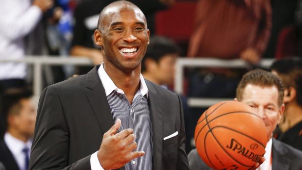 Ein lächelnder Kobe Bryant mit einem Spalding-Basketball.