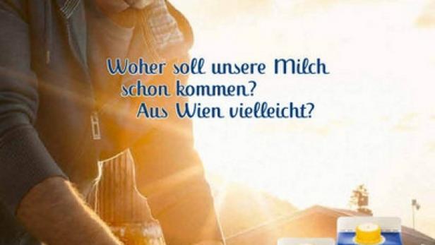 Ein Mann reinigt einen Milcheimer vor dem Hintergrund einer Tirol Milch Werbung.