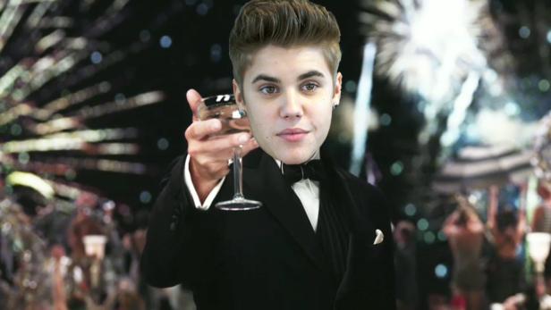 Justin Bieber im Smoking mit einem Glas Sekt vor einem festlichen Hintergrund.