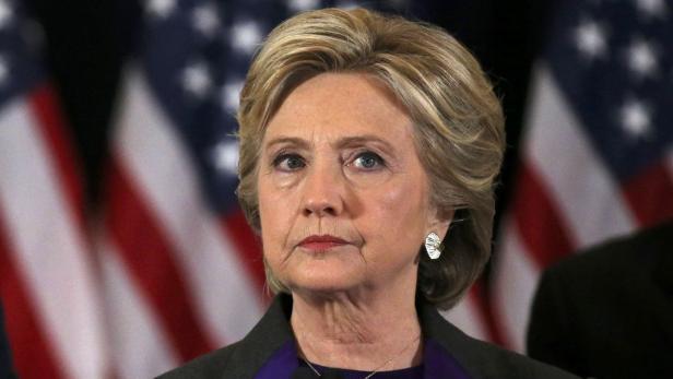 Ein Porträt von Hillary Clinton vor einer amerikanischen Flagge.