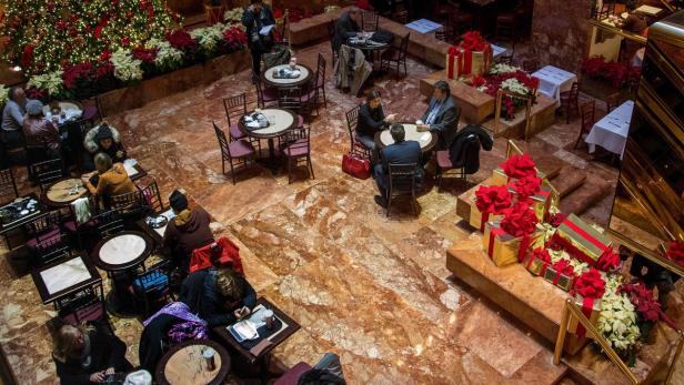 Ein Innenraum mit Tischen und Stühlen, dekoriert mit einem Weihnachtsbaum und Geschenken.