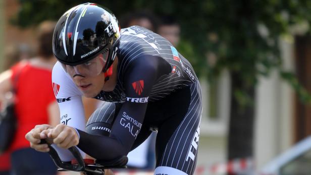 Ein Radrennfahrer mit Helm und aerodynamischer Haltung auf einem Rennrad.