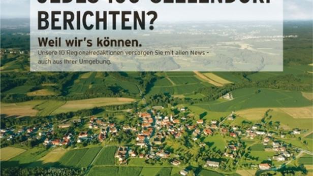 Luftaufnahme eines kleinen Dorfes umgeben von grünen Feldern und Wäldern.
