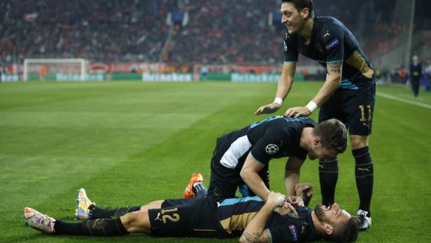Olivier Giroud (Boden) ließ sich von Mesut Özil (re.) und seinen Arsenal-Kollegen feiern.