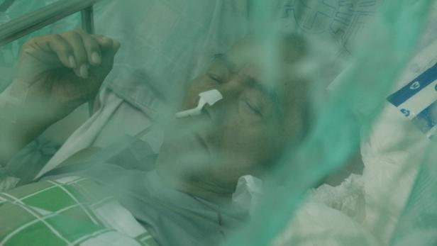 Ein älterer Mann liegt mit einer Nasensonde im Krankenhausbett.