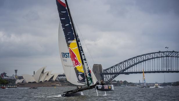 Ein Segelboot mit dem Red Bull Logo fährt vor der Kulisse des Opernhauses und der Harbour Bridge in Sydney.