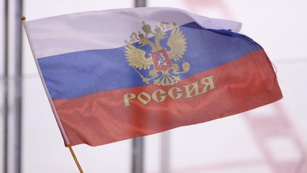 Eine russische Flagge mit dem russischen Wappen und dem Wort „Россия“ (Russland).