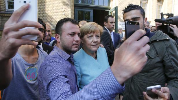Migranten aus Syrien und Irak mit der deutschen Kanzlerin Angela Merkel